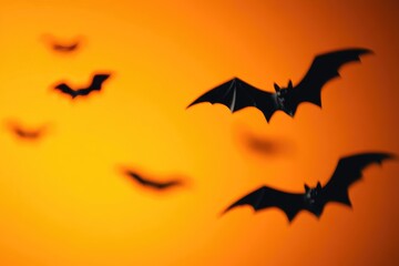 Fototapeta premium Eerie Black Bats in Flight Against Fiery Orange Sky