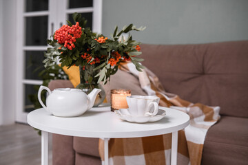 A Cozy Living Room Featuring a Soft Blanket, Lush Green Plants, and a Warm Cup of Coffee
