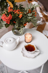Experience a Cozy Tea Time surrounded by Beautiful Flowers and Soft Candlelight for Charm