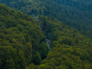 Curved mountain road. Aerial view of a beautiful wave road between the forests of a mountain. Beautiful motorways of the world.