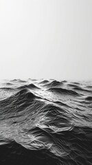 Vertical black and white photo capturing gentle waves on the sea surface. Minimalist and textured nature scene with copy space. Perfect as a calm, aesthetic background or wallpaper.