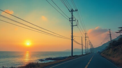 Electric poles lining a coastal road, with power lines extending out over the sea as the sun sets on the horizon.