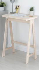 A modern home office desk is set up for creativity with drawing paper, crayons, watercolor pencils, and a glass of lemonade in a well-lit space