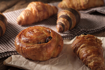 Freshly baked Raisin Danish Pastry and croissants. Arranged on a cloth and parchment paper.