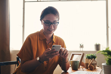 Woman, cellphone and scroll with smile for writing, blog or article in home office. Journalist,...