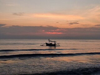 Obraz premium a fishing boat anchored on the north coast of Java, Indonesia with a sunrise atmosphere