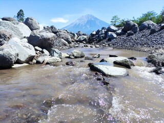 Mount Semeru during the day with a river foreground