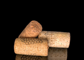 Three wine corks, macro, isolated on black background.