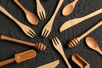 Different wooden kitchen utensils on black background