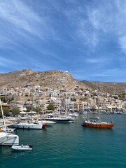 The harbour of Kalymnos with boats close up and the big painted greek flag