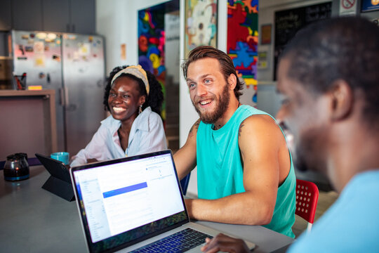 Group of friends working together in hostel common area