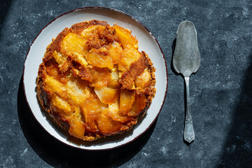 Traditional sliced fruit pie with apple and honey in plate , closeup, top view. Tarte tatin, type of French inside-out fruit pie in which the fruit is toasted in butter and sugar before pie is baked