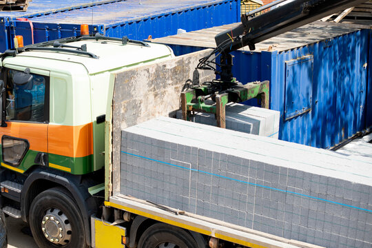 Efficient Loading of Construction Materials by a Crane on a Sunny Day at a Busy Construction Site