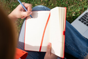 A Person Writes Creatively on the Grass, Enjoying the Warm Afternoon Sunlight