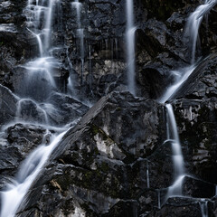 Water flowing and splashing through the rocks of a waterfall. Waterfall detail background. Crosis waterfalls, Tarcento, Udine, Friuli Venezia Giulia, Italy.