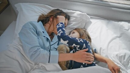 Affectionate parent kid lying soft bed at morning. Adorable family embracing - Powered by Adobe