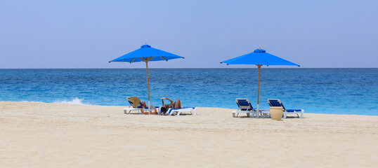 Obraz premium seaside resort beach with white sand and sun umbrellas