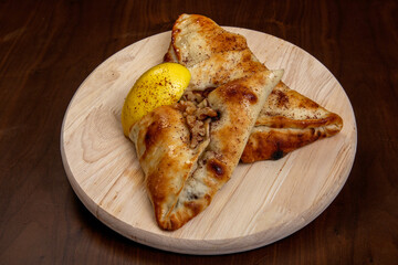 Plate with several different types of cheese fatayer, with minced lamb, Lebanese manakish, and meat and vegetables
