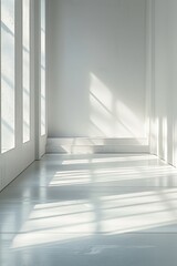 Obraz premium A serene interior space featuring soft sunlight casting gentle shadows on a white floor and walls, creating a tranquil atmosphere.