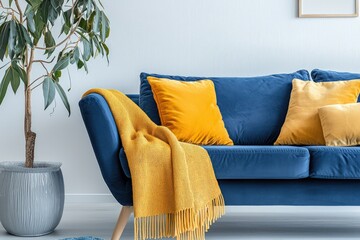 A Scandinavian living room with a blue sofa accented by yellow pillows and a blanket.