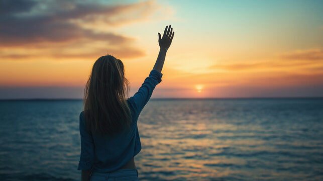Woman waving goodbye by the beach. View taken from behind.
