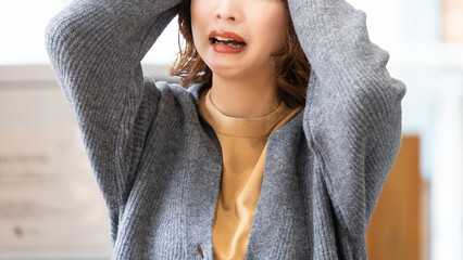 頭を抱えて困る女性
