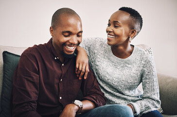 Black couple, laughing and love on sofa at house for funny relationship, bonding and commitment together. Smile, people and embrace for partner support, communication and comic joke of loyalty trust