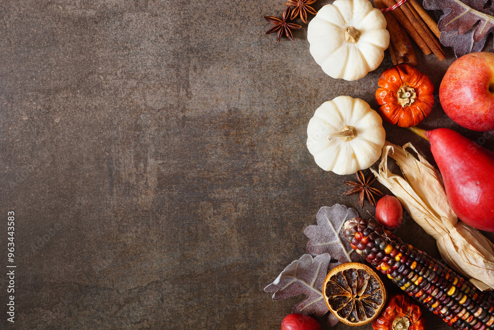 Poster autumn border of pumpkins, leaves and baking spices. side border on a dark stone background with cop