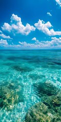 Naklejka premium A view of the ocean with clear blue water and white clouds