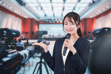 記者会見場からレポートをする女性記者