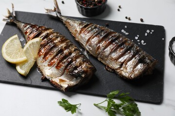 Delicious grilled mackerel, parsley, spices and lemon on white table