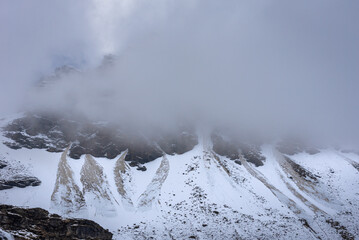 Snow cladded mountain view enroute Rupin pass trekking trail. It is a high altitude trek in Himachal Pradesh located at 4650m with Himalayan ranges, glacial meadows and snow-covered landscapes.