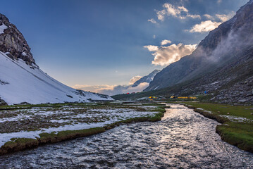 View during sunset from Rupin pass trek campsite. This trek is full of diversity from majestic Himalayan ranges to waterfalls, glacial meadows, snow-covered landscapes, lush forests in Himachal, India