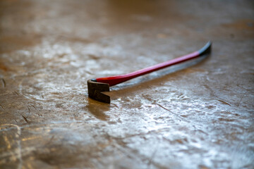 Red crowbar on concrete floor