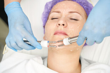 Naklejka premium Dermatology anti age treatment. Microcurrent medicine procedure. Woman skin care. Aesthetic peeling therapy. RF equipment. Cosmetology device at spa. Doctor hands in gloves. Wrinkle reduction