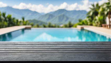 Naklejka premium The empty black wooden table top with blur background of swimming pool on the mountains. For product display