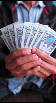 Vertical video of 100 nuevos soles banknotes. Peruvian currency