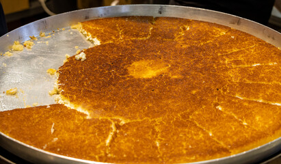 Traditional Turkish and Middle Eastern dessert in a big tray: Knafeh (Turkish: Kunefe)