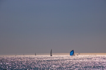 océan avec lumière du soir et voiles de bateaux à l'horizon