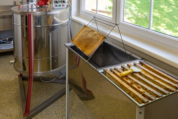 Equipment for beekeeping, demonstrating a hood and frames for honeycombs, ready for processing, a honey machine.