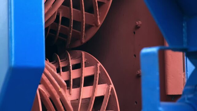 Rotating mechanism inside industrial wood debarking machine on woodworking plant. Part of conveyor line in timber manufacturing. Engineering technology in production. Modern equipment on factory.
