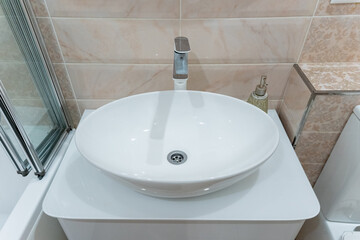 This is a modern white round bathroom sink featuring a sleek faucet, perfectly designed for a contemporary setting and elegant decor