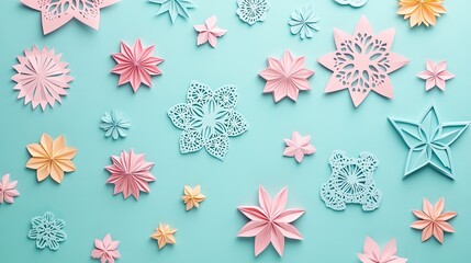 Colorful paper flowers and snowflakes of various shapes scattered on a light blue background for creative design projects.