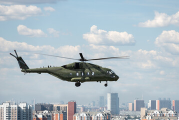 Russian multi-purpose transport helicopter military colors force over the city blue sky clouds sunny day