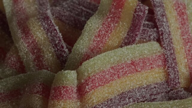 Sour belts candy texture rotating macro. Candy and sweets. Unhealthy food