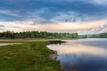A lake with a cloudy sky in the background