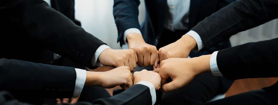 Office worker team stacking hand together symbolize successful group of business partnership and strong collective unity teamwork in community workplace in panoramic banner. Shrewd