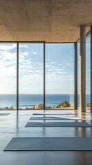 Fototapeta premium Tranquil yoga studio with floor-to-ceiling windows overlooking the ocean.