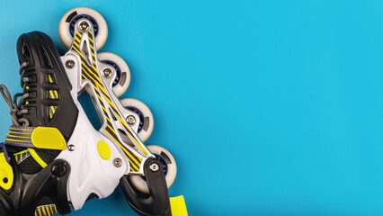 Stylish roller skates on blue background, top view. Inline skates isolated on blue, extreme sports...