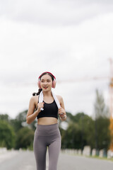 Urban Rhythm: Young Asian woman finds her stride, energized and motivated on her morning run. 